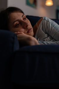 Portrait of young woman sitting on sofa at home