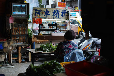 Rear view of boy sitting at shop