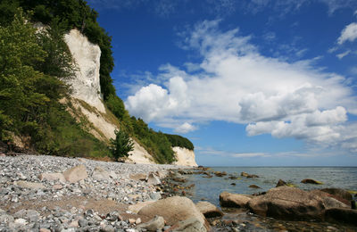 Scenic view of rocks on beach against sky