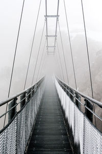 Empty narrow footbridge against the sky