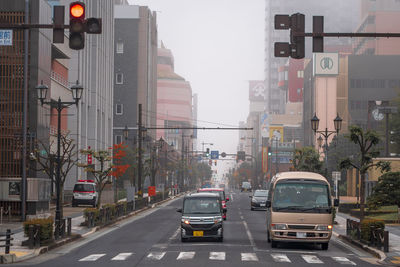 Traffic on city street and buildings against sky