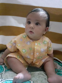 Portrait of cute baby lying on bed