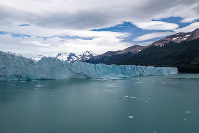 Scenic view of lake and snowcapped mountains against sky