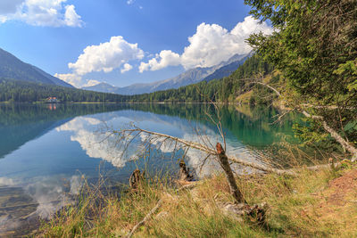 Scenic view of lake by mountains against sky