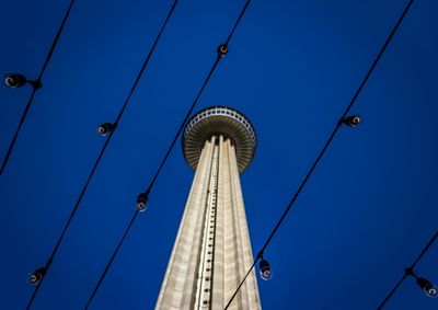 Low angle view of communications tower against blue sky