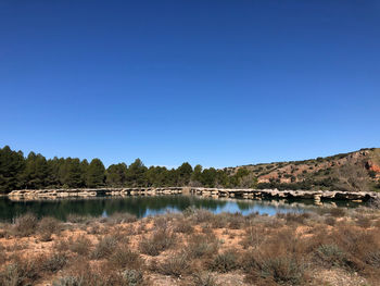 Scenic view of lake against clear blue sky