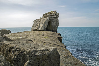 Scenic view of rock formation in sea against sky