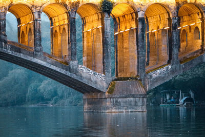 Arch bridge with light on over river