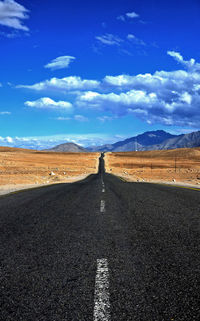 Empty road against blue sky