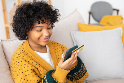 Young woman using mobile phone at home