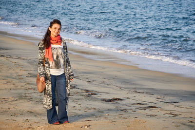 Portrait of young woman standing on beach