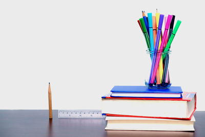 Close-up of colored pencils on table against white background