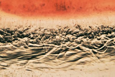 Close-up of sand on beach against sky during sunset