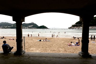 People at beach against sky