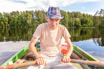 Portrait of young woman sitting on boat in lake