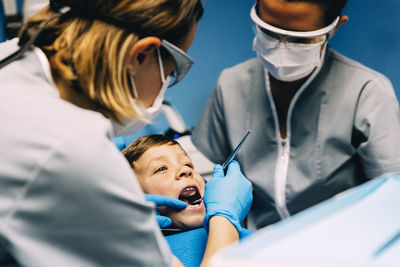 Dentists examining boy in clinic