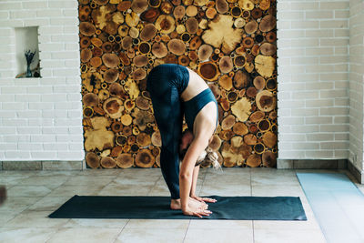 Full length of woman stretching at home