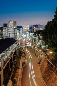 High angle view of light trails on road amidst buildings in city