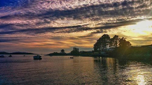 Scenic view of sea against cloudy sky at sunset