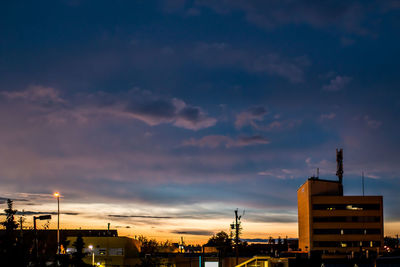 Buildings against cloudy sky at sunset