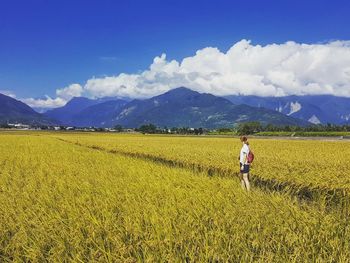 Man standing in farm field against sky