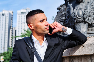 Young man looking away in city