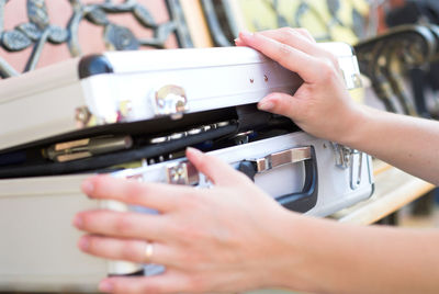 Cropped hands of woman opening briefcase