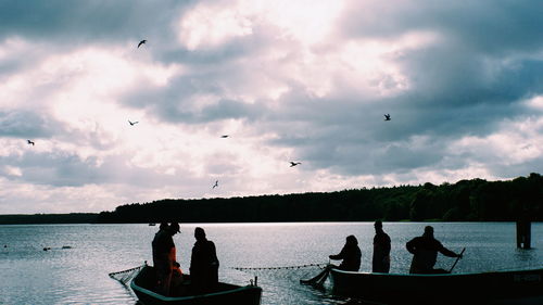 People at birds against sky