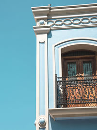 High section of cropped built structure against blue sky