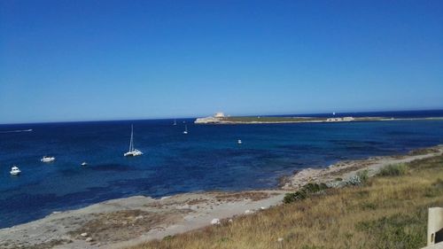 Scenic view of sea against clear blue sky