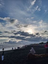 People on beach against sky