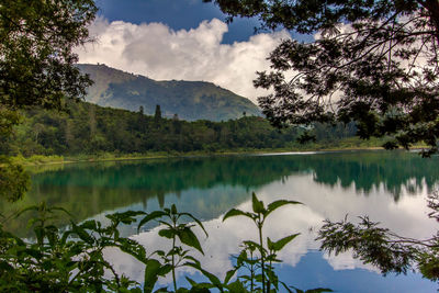 Scenic view of lake by mountain against sky
