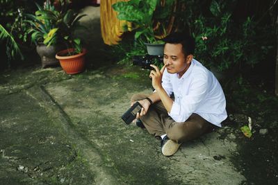 Young man sitting on plant