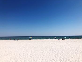 Scenic view of beach against clear blue sky