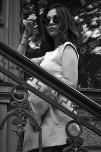 Portrait of woman standing by railing