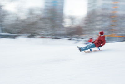 Rear view of boy riding motorcycle on snow