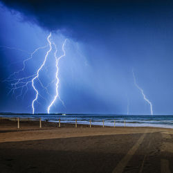 Lightning over sea against sky at night