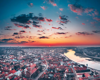 Aerial view of city street and buildings against sky during sunset