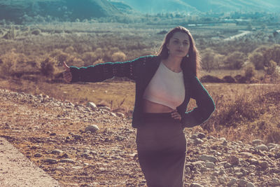 Portrait of young woman standing on field