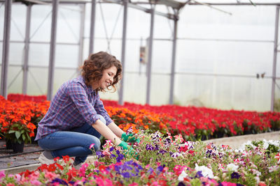 Smiling woman working in greenhouse