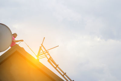 Low angle view of woman standing against sky