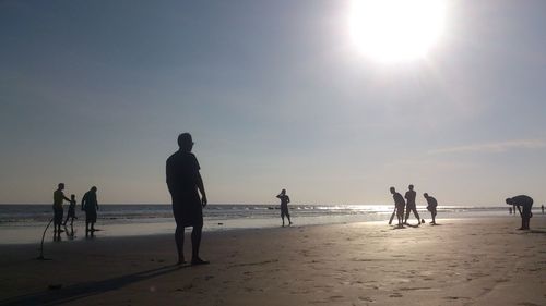 People enjoying at beach during sunny day