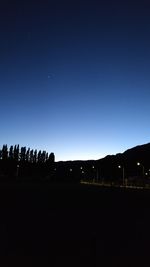 Silhouette landscape against clear sky at night