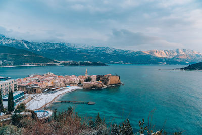 Scenic view of sea by city against sky