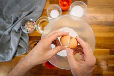 Midsection of man holding egg and cooking in kitchen