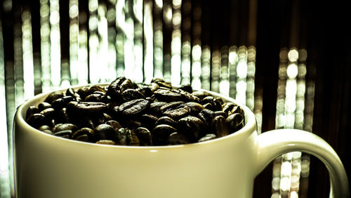 Close-up of roasted coffee beans in cup