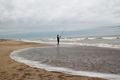 Fishermen on the beach, details of bait and lines of fishing rods.man fishing at beach against sky