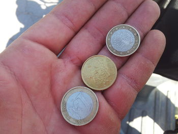 Close-up of hand holding coins