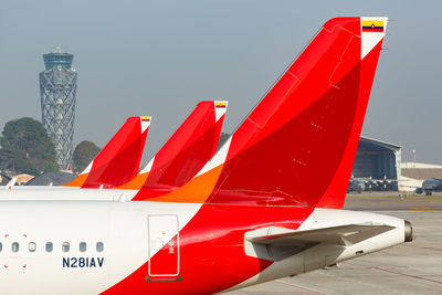 Close-up of airplane on airport runway against sky