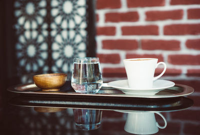 Turkish mocha coffee on metal tray with water in small glass.